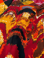 Colorful abstract Ankara pattern with red, yellow, black, and brown colors.